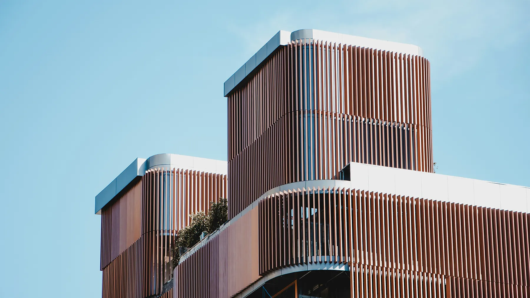 Fachada do Edifício LM, com brise vertical de madeira e volume superior recuado
